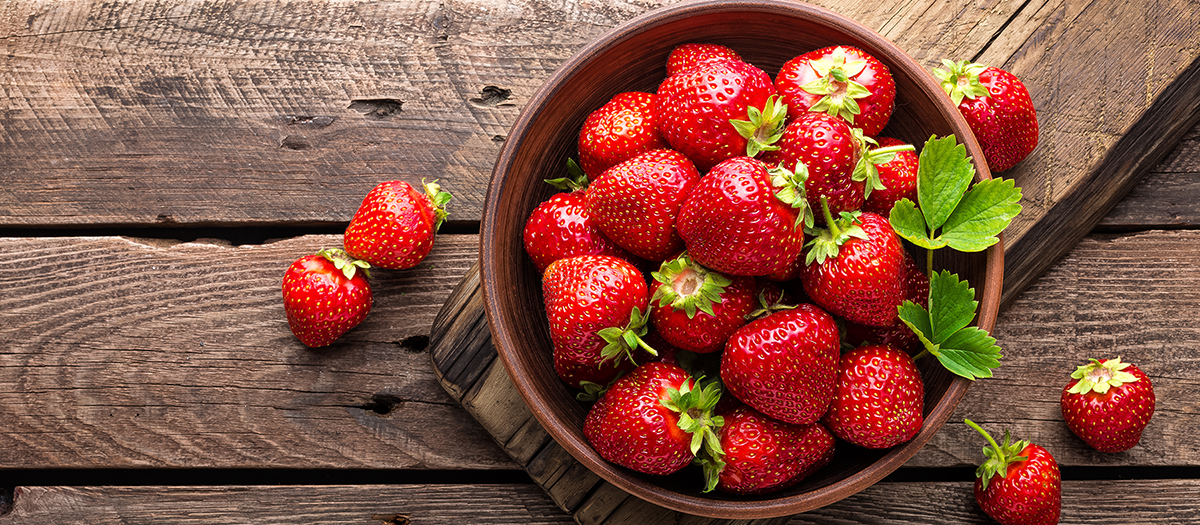 Schale mit frischen Erdbeeren auf einem Holztisch